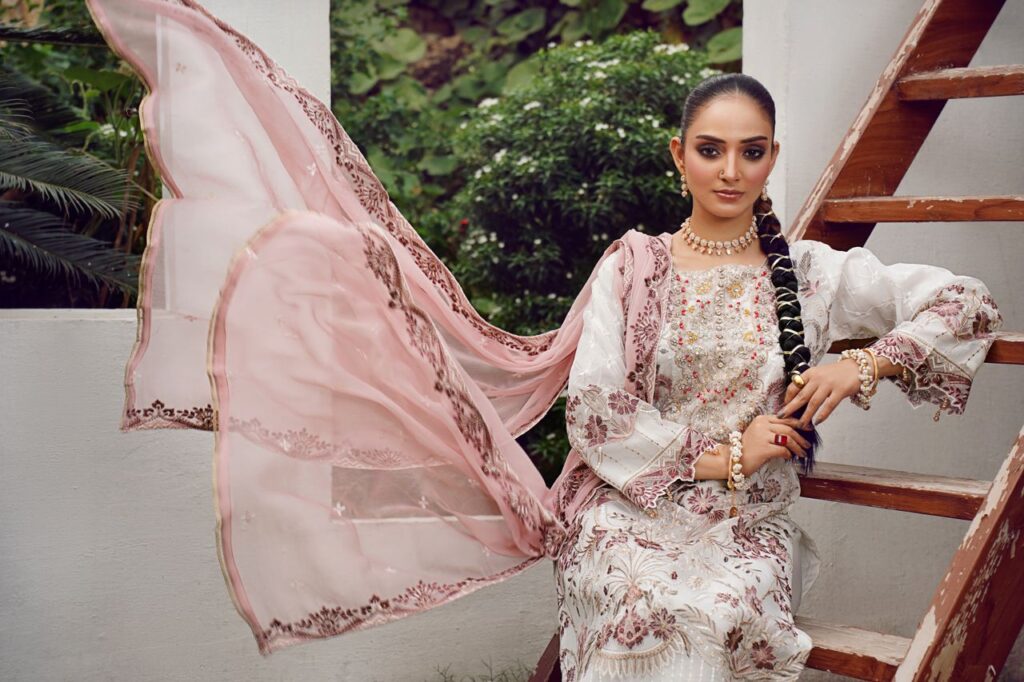 Model in traditional attire with flowing scarf, posing outdoors in Lahore, Pakistan.